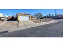 Front view of a charming house with a driveway and desert landscaping at 451 Wright Way, Henderson, NV 89015