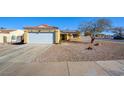 Cute yellow house with a single car garage and desert landscaping at 451 Wright Way, Henderson, NV 89015