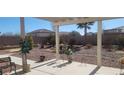 Landscaped backyard with a covered patio, desert plants, and a relaxing view at 4641 Sommerset Ct, Pahrump, NV 89061