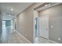 A spacious hallway with tile flooring and neutral walls leads to various rooms in the house at 4641 Sommerset Ct, Pahrump, NV 89061