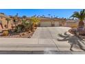 Landscaped front yard with desert plants and a long driveway leading to a two-car garage at 526 Highland View Ct, Mesquite, NV 89027