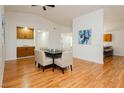 Bright dining room with hardwood floors, vaulted ceilings, and a modern table set for six at 9741 Horizon Hills Dr, Las Vegas, NV 89117