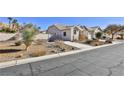 Landscaped yard with drought-tolerant plants and a driveway at 1248 Abadan St, Las Vegas, NV 89142