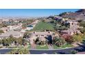 Stunning aerial view of the estate showcasing the golf course, city, and mountain views at 1549 Foothills Village Dr, Henderson, NV 89012