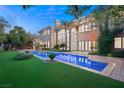 Inviting pool and spa with artificial turf and landscaping at 1549 Foothills Village Dr, Henderson, NV 89012