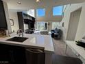 Modern kitchen island overlooks the open living room with high ceilings and large windows at 2260 Village Walk Dr # 1309, Henderson, NV 89052