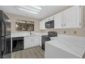 Well-lit kitchen features white cabinets, black appliances, quartz countertops, and window with natural light at 2851 S Valley View Blvd # 1195, Las Vegas, NV 89102