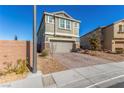 Two-story house with a gray exterior, brick accents, and a two-car garage at 3032 Gravino Ave, Henderson, NV 89044