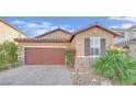 Single-story home with brown garage door, stone accents, and landscaped yard at 5344 Bocopa St, Las Vegas, NV 89148