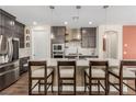 Modern kitchen with a breakfast bar and dark cabinetry at 6524 Summershade St, North Las Vegas, NV 89086