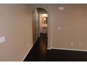 Hallway with dark hardwood floors leading to a half bath with pedestal sink at 10264 Headrick Dr, Las Vegas, NV 89166