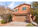 Two-story house with tan exterior, two-car garage, and landscaping at 1512 Groom Ave, North Las Vegas, NV 89081