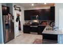 A modern kitchen with granite countertops, stainless steel appliances, and dark wood cabinets at 2509 Piacenza Pl, Henderson, NV 89044