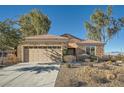 One-story house with stone exterior, two-car garage, and desert landscaping at 2551 Darda St, Henderson, NV 89044