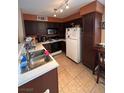 Galley kitchen with dark cabinets and white appliances at 3038 Casey Dr # 204, Las Vegas, NV 89120