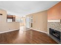 Open-concept living room featuring beautiful hardwood floors and a cozy mosaic-tiled fireplace at 3038 Casey Dr # 204, Las Vegas, NV 89120