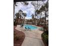 Community pool with palm trees and patio furniture at 3038 Casey Dr # 204, Las Vegas, NV 89120