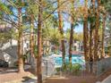 Community pool area surrounded by trees and lounging chairs at 3038 Casey Dr # 204, Las Vegas, NV 89120