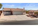 Single-story home with a tile roof, two-car garage, and a spacious driveway in a quiet neighborhood at 3280 James A Bilbray Pkwy, Laughlin, NV 89029