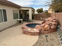 Relaxing backyard with a spa, waterfall, and patio seating at 3310 Fernbird Ln, North Las Vegas, NV 89084