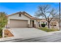 Tan house with a brown garage door and a tree in front at 3708 Penny Cross Dr, North Las Vegas, NV 89032