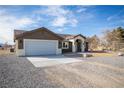 Single-story home features a gravel front yard, two-car garage, and well-kept landscaping at 3880 Leonard St, Pahrump, NV 89060