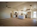 Bright open kitchen features white cabinetry, stainless steel appliances, and a center island with seating at 3880 Leonard St, Pahrump, NV 89060