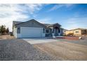 Beautiful single-story house featuring a two-car garage, driveway, gravel yard, and desert landscaping at 3960 Dart Dr, Pahrump, NV 89060