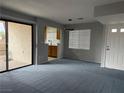 Open-concept living space with a sliding glass door, window, and view of the kitchen at 4707 Nara Vista Way # 104, Las Vegas, NV 89103