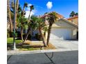 Tan two-story house with a tile roof, palm trees, and a grassy yard at 5508 Big Sky, Las Vegas, NV 89149