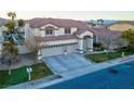 Two-story house with three-car garage and landscaped yard at 553 Sinfold Park St, Las Vegas, NV 89148