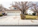 House exterior showcasing a three-car garage and manicured lawn at 575 Dusty Palms Ln, Henderson, NV 89052