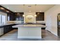 Modern kitchen with dark cabinetry, granite counters, and a large island at 6050 Belvedere Canyon Ave, Las Vegas, NV 89139