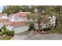 Aerial view of charming two-story home with tile roof and attached garage at 6973 Emerald Springs Ln, Las Vegas, NV 89113