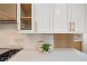 Kitchen detail showcasing white shaker cabinets with gold hardware and quartz countertops at 7 Summit Walk Trl, Henderson, NV 89052