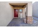 Front entry with red door and stone accents at 7141 Liberty Landing St, Las Vegas, NV 89166