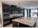 Spacious kitchen with dark cabinetry, granite countertops, and stainless steel appliances at 8157 Lennox View Ln, Las Vegas, NV 89113