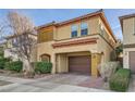 Tan two-story house with brown garage door and landscaping at 8477 Orly Ave, Las Vegas, NV 89143