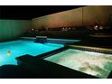 Inviting pool and spa area with waterfall feature and night lighting at 9366 W Viking Rd, Las Vegas, NV 89147