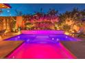 Inviting pool with a waterfall feature and colorful LED lighting at 10414 Hemingway Ct, Las Vegas, NV 89149