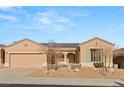 Tan colored house with solar panels, landscaping, and a two-car garage at 2000 Poppywood Ave, Henderson, NV 89012