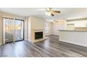 Living room with fireplace, laminate flooring, and access to patio and kitchen at 2983 Juniper Hills Blvd # 203, Las Vegas, NV 89142