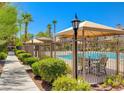 Community pool with patio furniture and shade structures at 3820 Wiggins Bay St # 201, Las Vegas, NV 89129