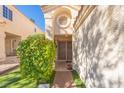 Inviting front entrance with a security door, mature landscaping, and a unique architectural design at 433 Jubilation Dr, Las Vegas, NV 89145