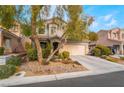 Two story house with attached garage and landscaped yard at 5992 Genovese Ave, Las Vegas, NV 89141