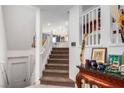 Bright, modern staircase leading to an open-concept living space and kitchen with stylish decor at 6075 Wyndham Estate Ave, Las Vegas, NV 89141