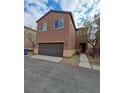 Two-story house with brown exterior and a two-car garage at 690 Calamus Palm Pl, Henderson, NV 89011