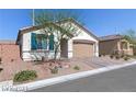 A charming single-story home featuring a two-car garage and desert landscaping, bathed in bright sunlight at 7129 Flora Lam St, Las Vegas, NV 89166