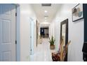 Bright hallway with white tile flooring, recessed lighting, and tasteful decorations at 7129 Flora Lam St, Las Vegas, NV 89166