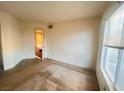 Empty bedroom with carpet, large window, and door to hallway at 8070 W Russell Rd # 2068, Las Vegas, NV 89113